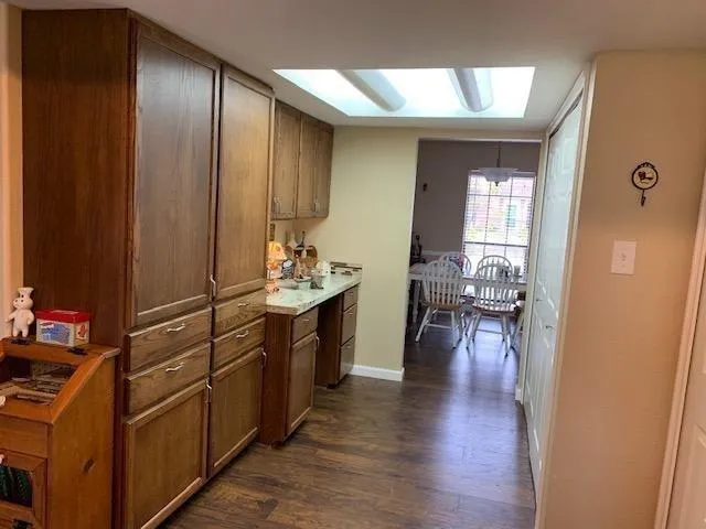 a view of a hallway kitchen with wooden floor and furniture