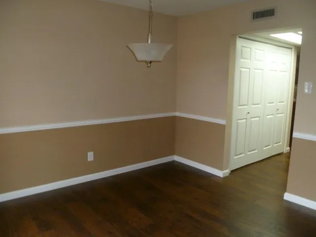 an empty room with wooden floor and cabinet