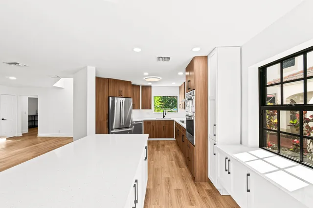 a large white kitchen with a large window