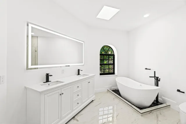 a white bath tub sitting next to a shower