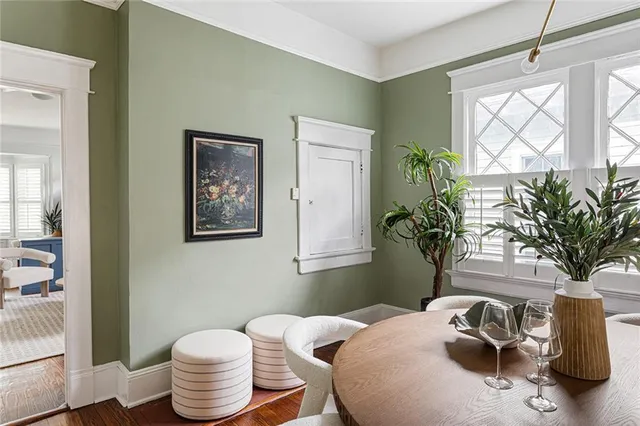 a kitchen with stainless steel appliances a dining table chairs refrigerator and sink