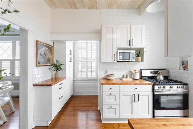a bed sitting in a bedroom next to a window with a chandelier