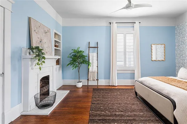a living room with furniture and a potted plant on table and wooden floor