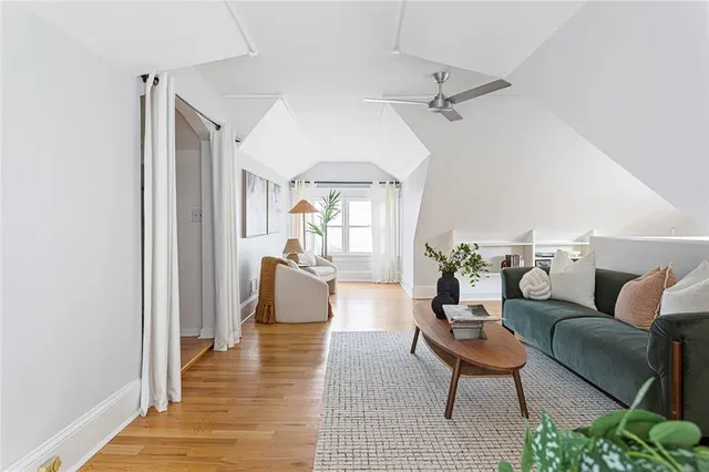a side view of a house with a tree and flower plants
