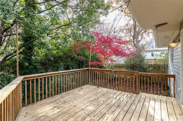 a view of the patio with dining table and chairs under an umbrella