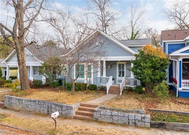 a view of a brick building with large window and potted plants