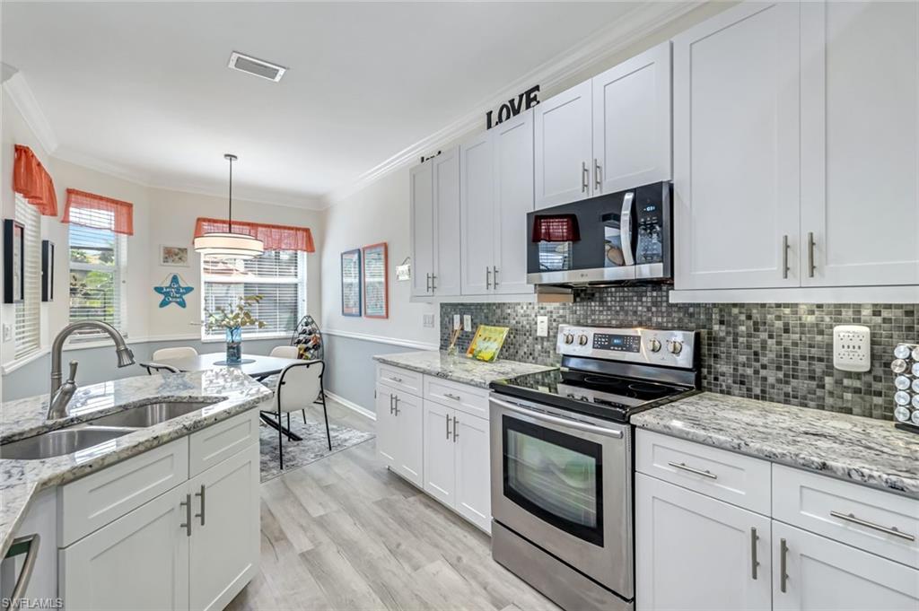 20050 Rookery Drive Estero, FL 33928 - Photo 16 of 45 a kitchen with stainless steel appliances granite countertop a stove a sink and a microwave