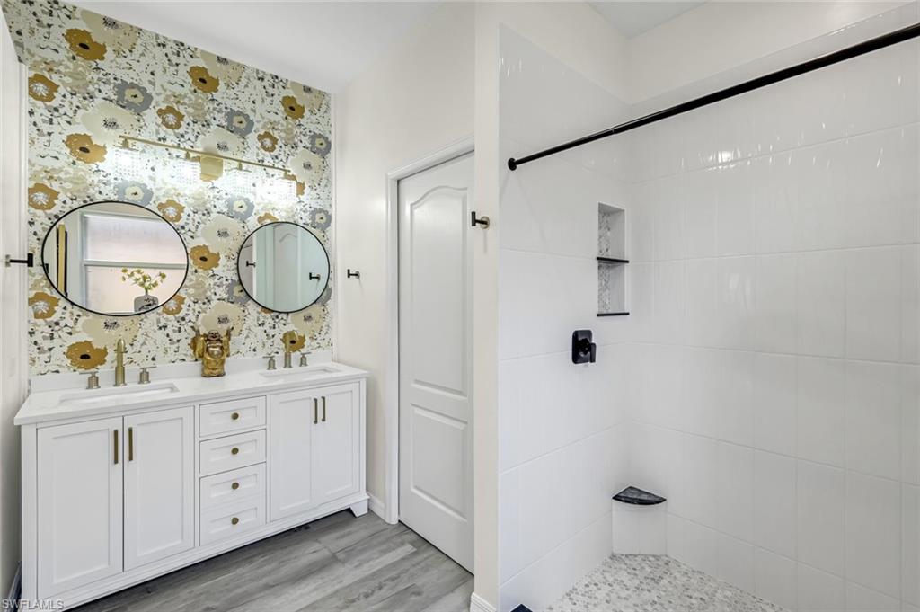 20050 Rookery Drive Estero, FL 33928 - Photo 21 of 45 a bathroom with a granite countertop sink toilet a mirror a vanity and shower