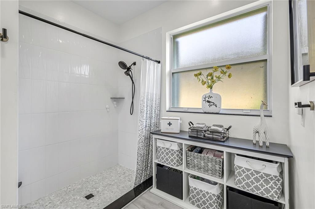 20050 Rookery Drive Estero, FL 33928 - Photo 22 of 45 a bathroom with a sink a mirror and a shower