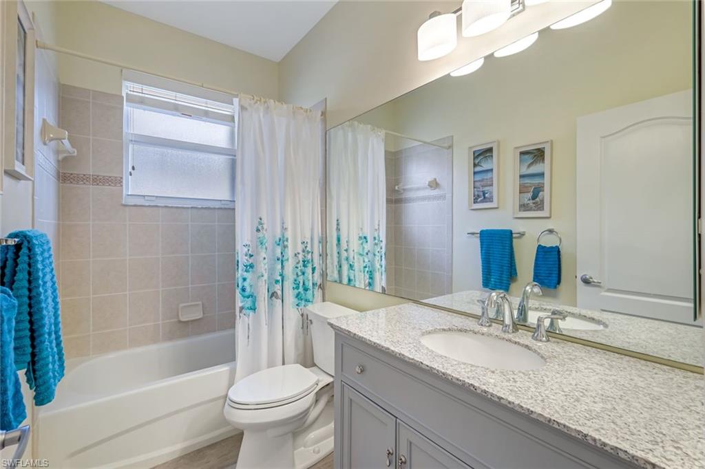 20050 Rookery Drive Estero, FL 33928 - Photo 26 of 45 a bathroom with a granite countertop sink a toilet and bathtub