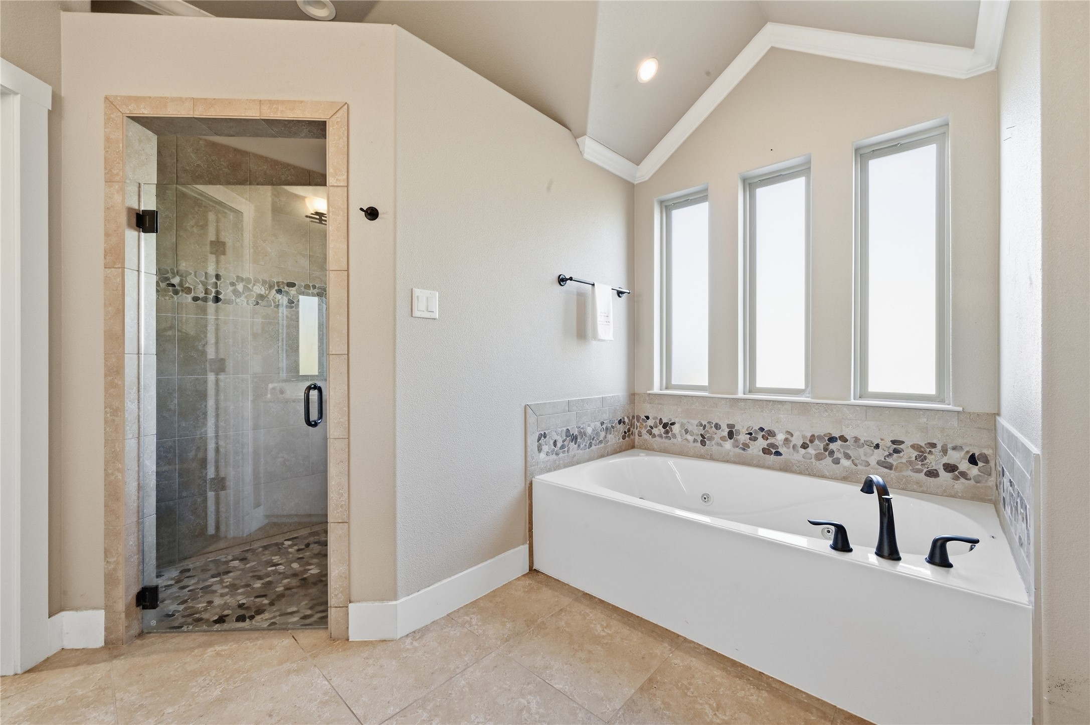 4467 West Amity Road Salado, TX 76571 - Photo 21 of 40 Bathroom featuring a built-in bathtub with dark fixtures, an accent tile border, and three tall windows