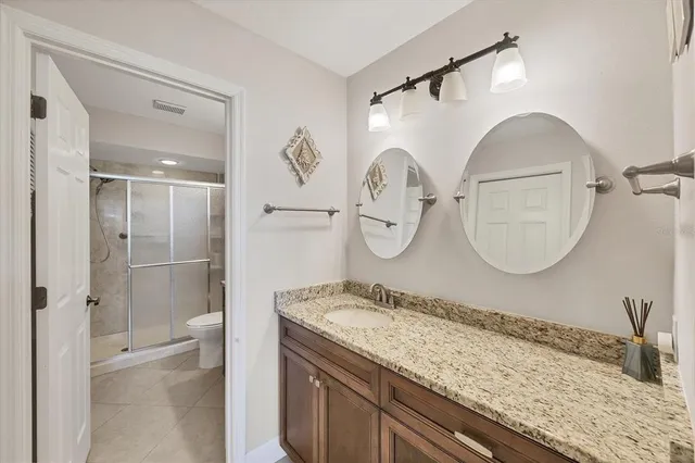 a bathroom with a granite countertop sink mirror and vanity