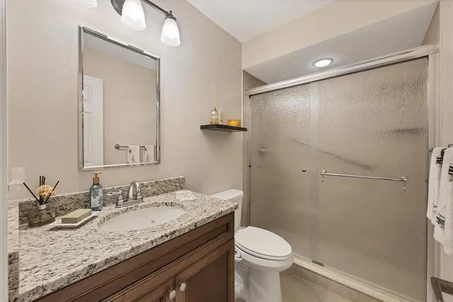 a bathroom with a granite countertop sink toilet and shower