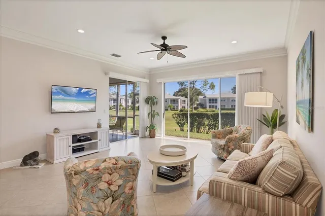 a living room with furniture a flat screen tv and a large window