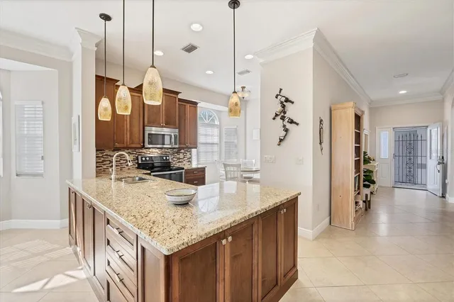 a kitchen with stainless steel appliances granite countertop a sink a oven and a refrigerator with wooden floor