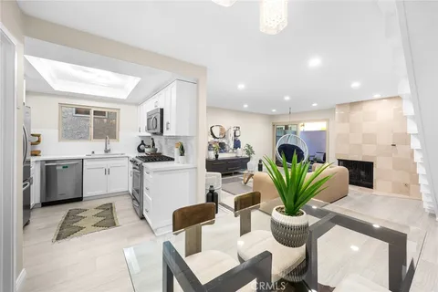 a dining room filled chandelier and kitchen view
