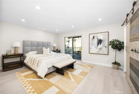 a bedroom with a large bed and a chandelier