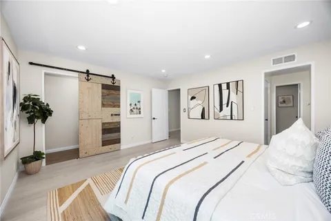 a bedroom with a bed and a potted plant