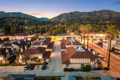 an aerial view of residential houses with outdoor space and trees