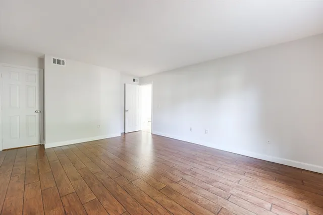 a view of an empty room and wooden floor