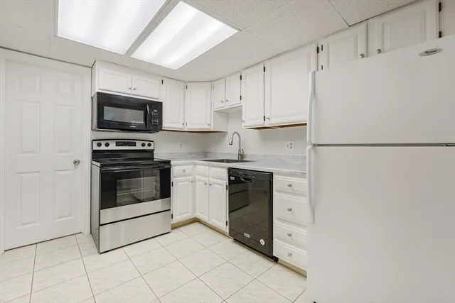 a kitchen with white cabinets and white appliances