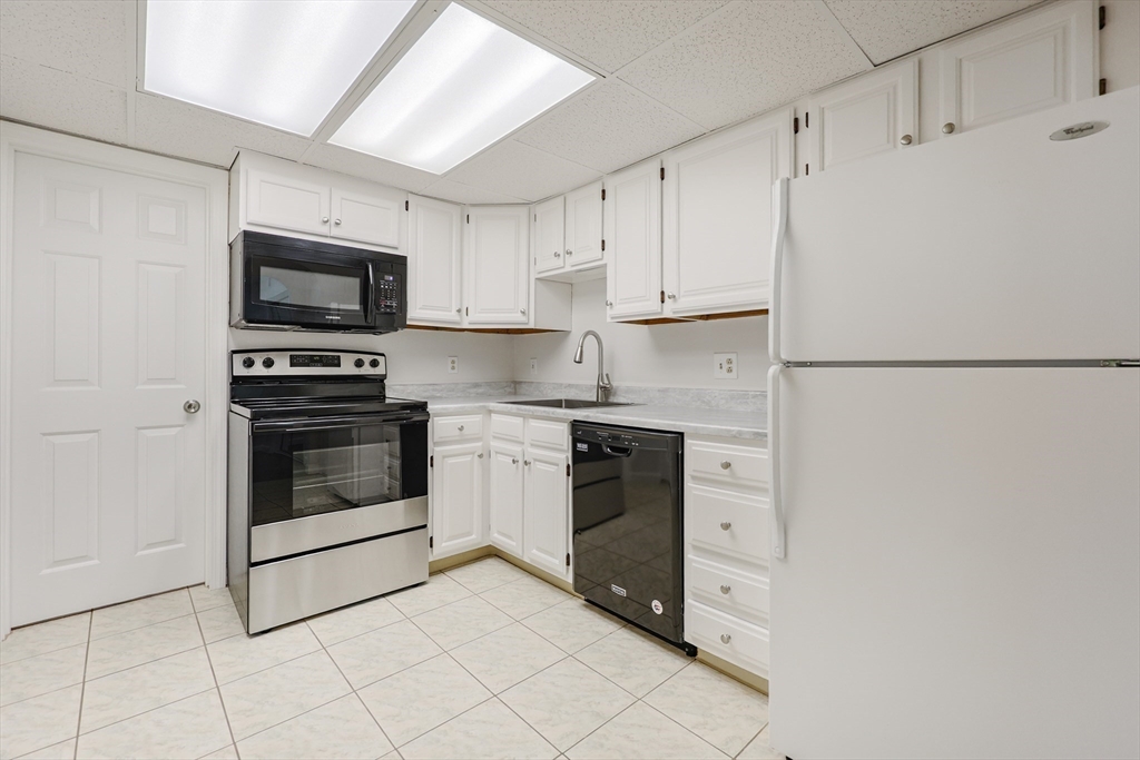 14 Shadowbrook Lane, Unit 30 Milford, MA 01757 - Photo 6 of 18 a kitchen with white cabinets and white appliances