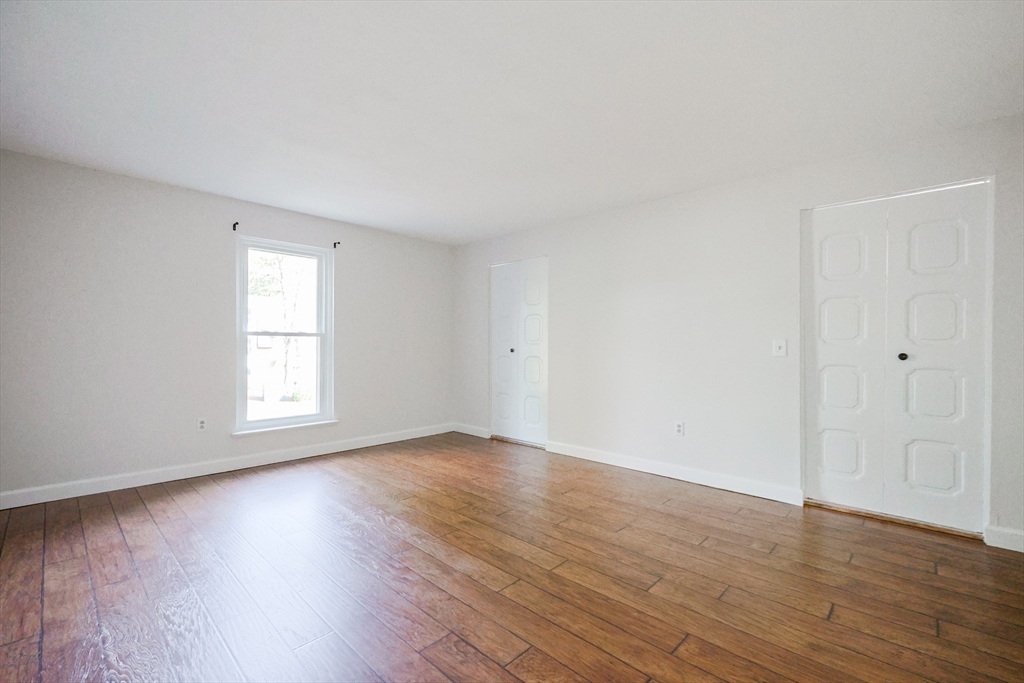 14 Shadowbrook Lane, Unit 30 Milford, MA 01757 - Photo 8 of 18 a view of an empty room with wooden floor and window