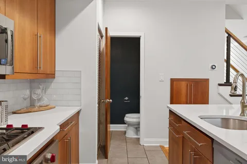 a kitchen with a sink and a stove with wooden floor