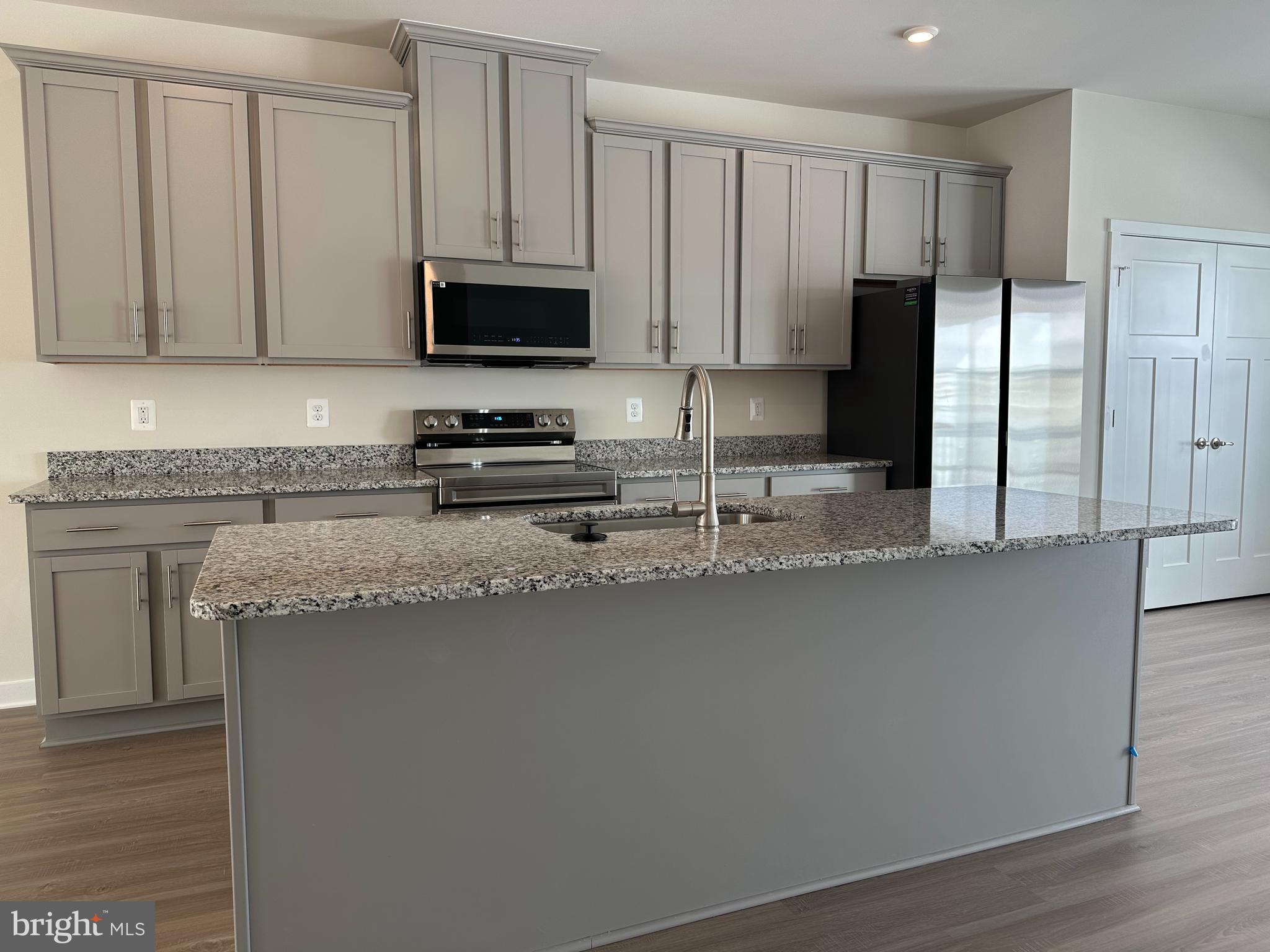 69 Trotting Road Inwood, WV 25428 - Photo 11 of 43 a kitchen with stainless steel appliances granite countertop a refrigerator a stove a sink and white cabinets with wooden floor
