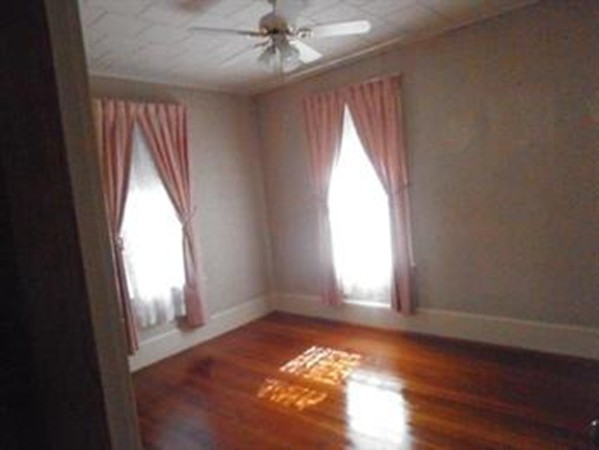 53 Calumet Road Holyoke, MA 01040 - Photo 4 of 12 an empty room with wooden floor fan and windows