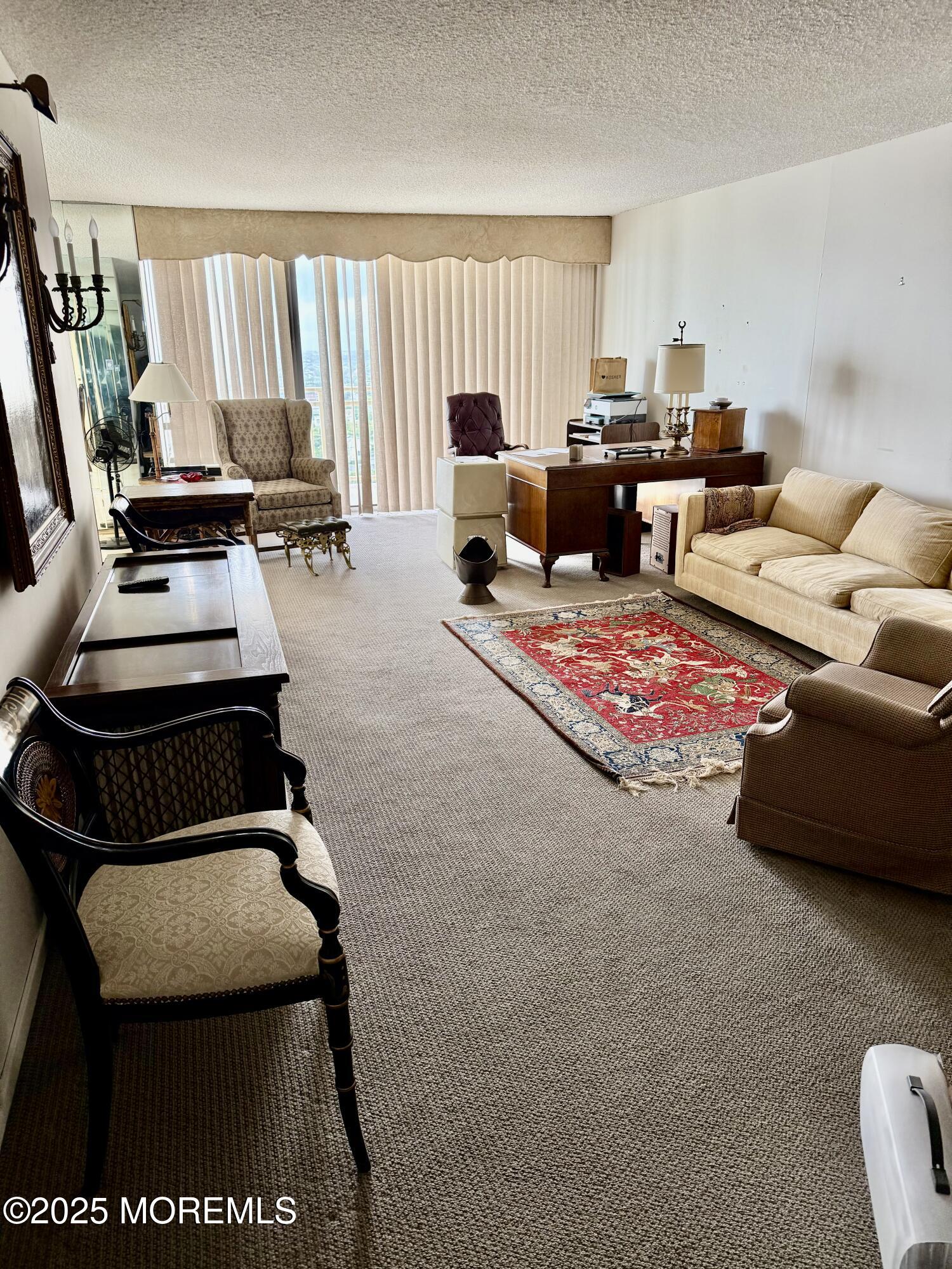 787 Ocean Avenue, Unit 1906 Long Branch, NJ 07740 - Photo 2 of 7 a living room with furniture and a flat screen tv