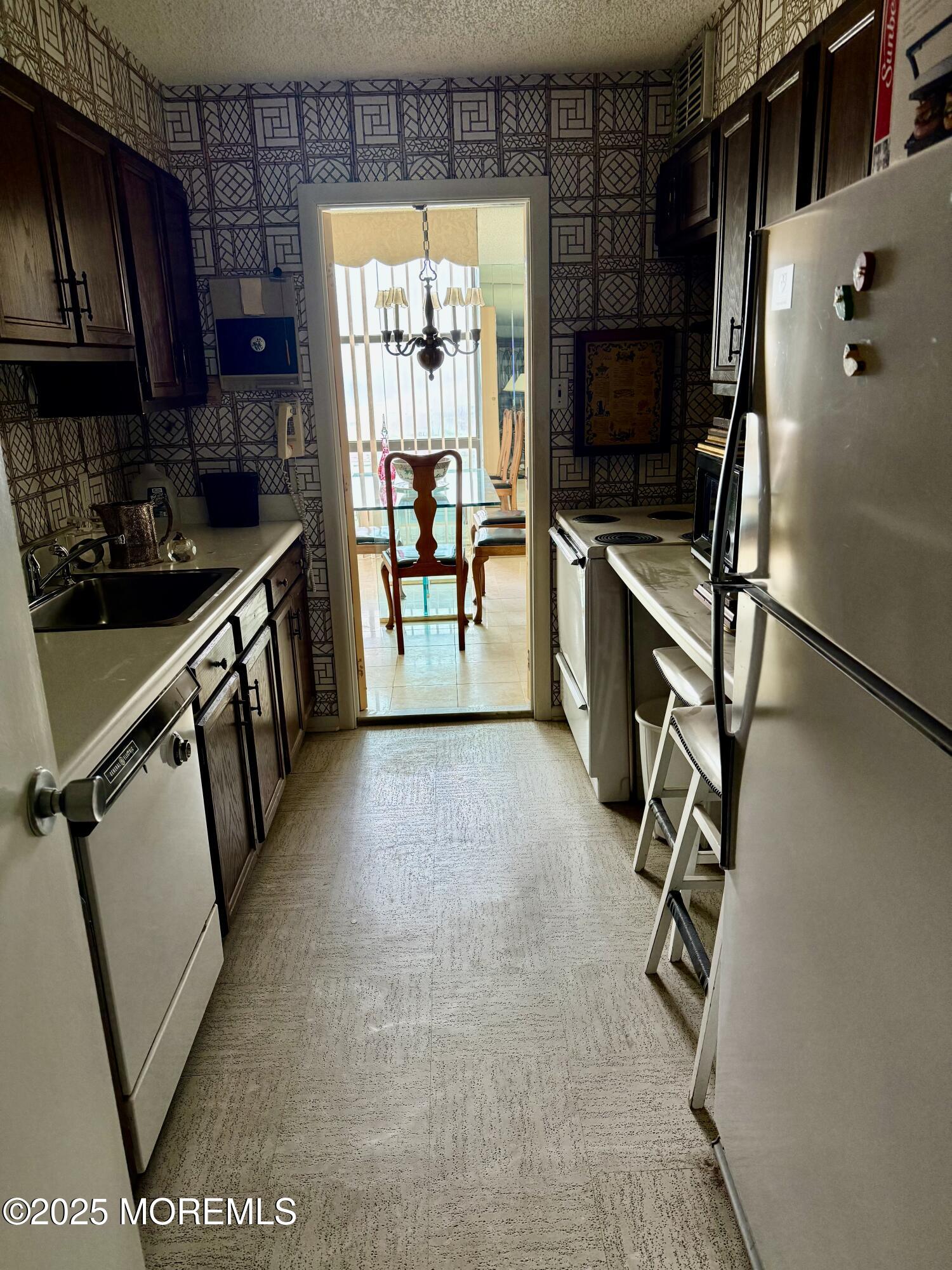 787 Ocean Avenue, Unit 1906 Long Branch, NJ 07740 - Photo 3 of 7 a kitchen with stainless steel appliances a refrigerator and a sink