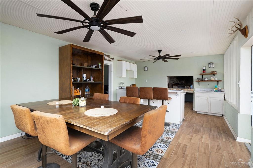 0 Out Of Area Roma, TX 78584 - Photo 8 of 23 a dining room with wooden floor a chandelier fan a wooden table and chairs