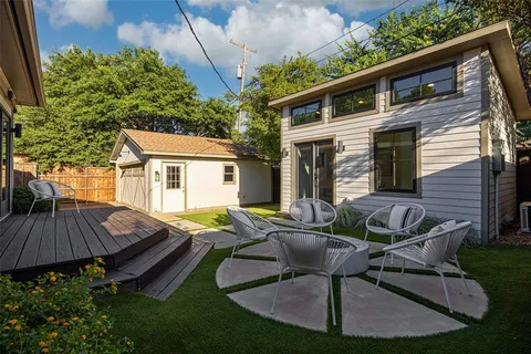 a view of house with backyard and outdoor seating