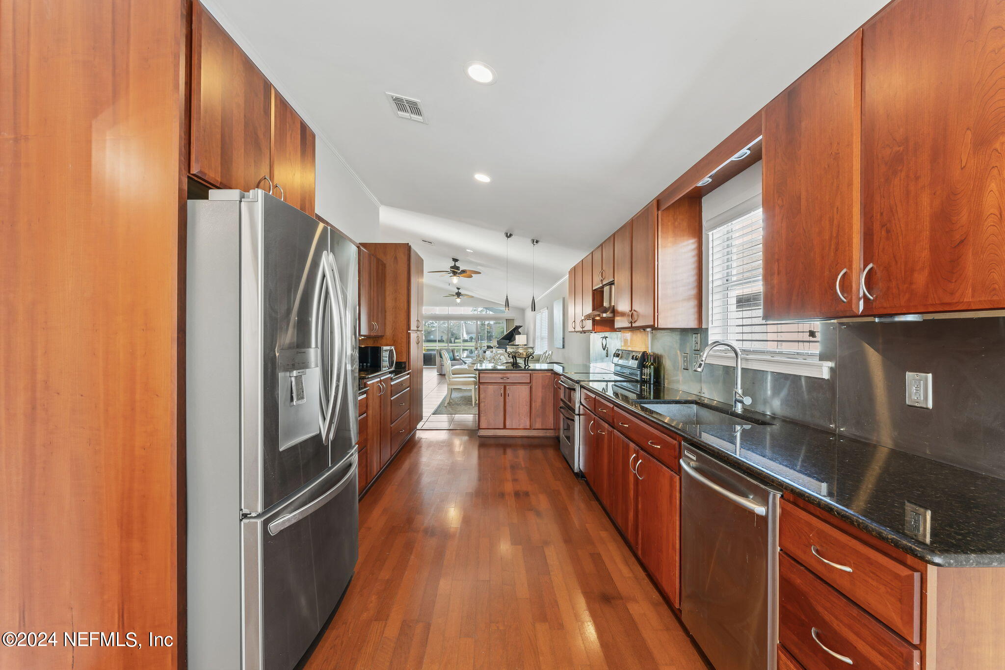 256 Patrick Mill Circle Ponte Vedra Beach, FL 32082 - Photo 12 of 69 a kitchen with stainless steel appliances granite countertop a refrigerator a sink dishwasher a stove and white countertops with wooden floor