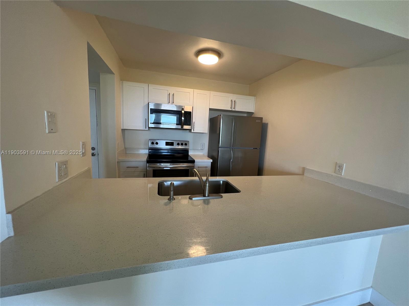 8120 Geneva Court, Unit 554 Doral, FL 33166 - Photo 18 of 32 a kitchen with a refrigerator and chairs