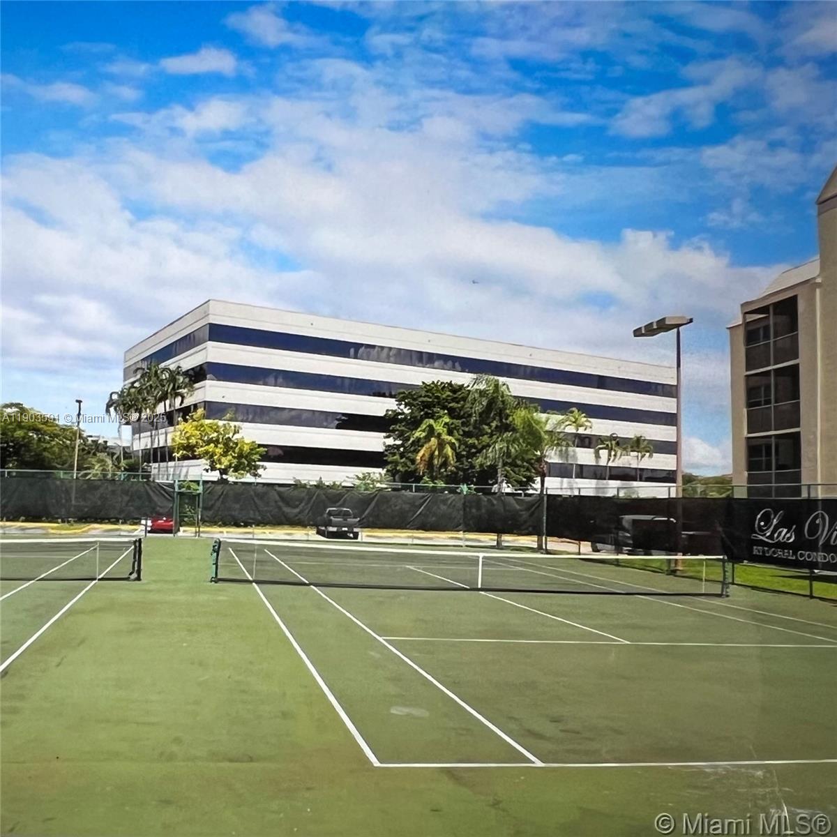 8120 Geneva Court, Unit 554 Doral, FL 33166 - Photo 22 of 32 a view of a tennis ground with large trees