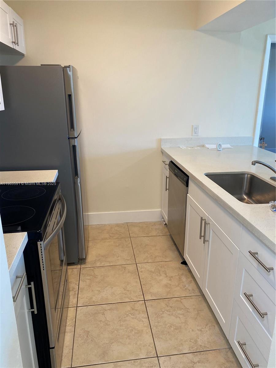 8120 Geneva Court, Unit 554 Doral, FL 33166 - Photo 27 of 32 a kitchen with a sink a refrigerator and washer