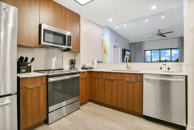 a kitchen with stainless steel appliances granite countertop a sink and microwave