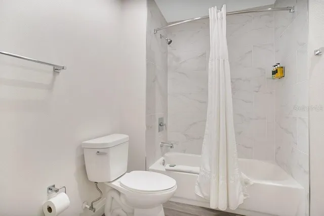 a bathroom with a toilet and a shower