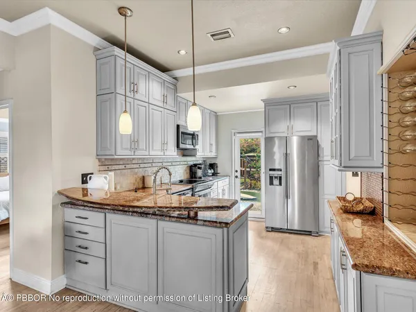 a kitchen with granite countertop a sink appliances cabinets and a counter top space