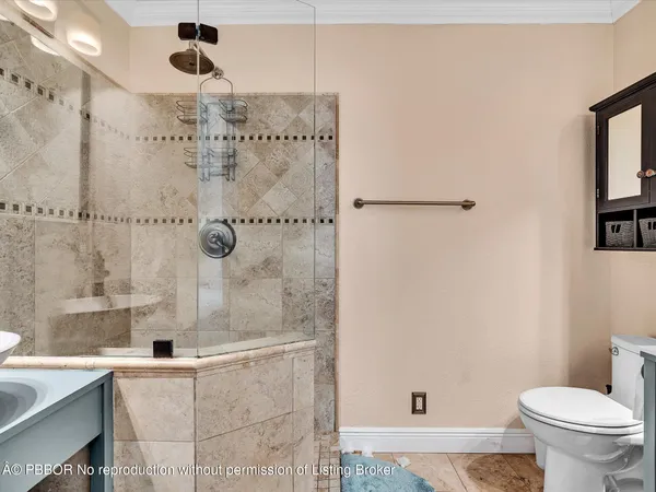 a bathroom with a granite countertop sink a toilet and shower