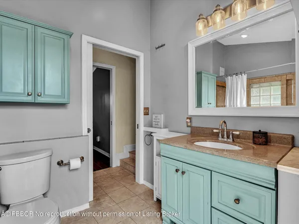a bathroom with a granite countertop sink toilet and mirror