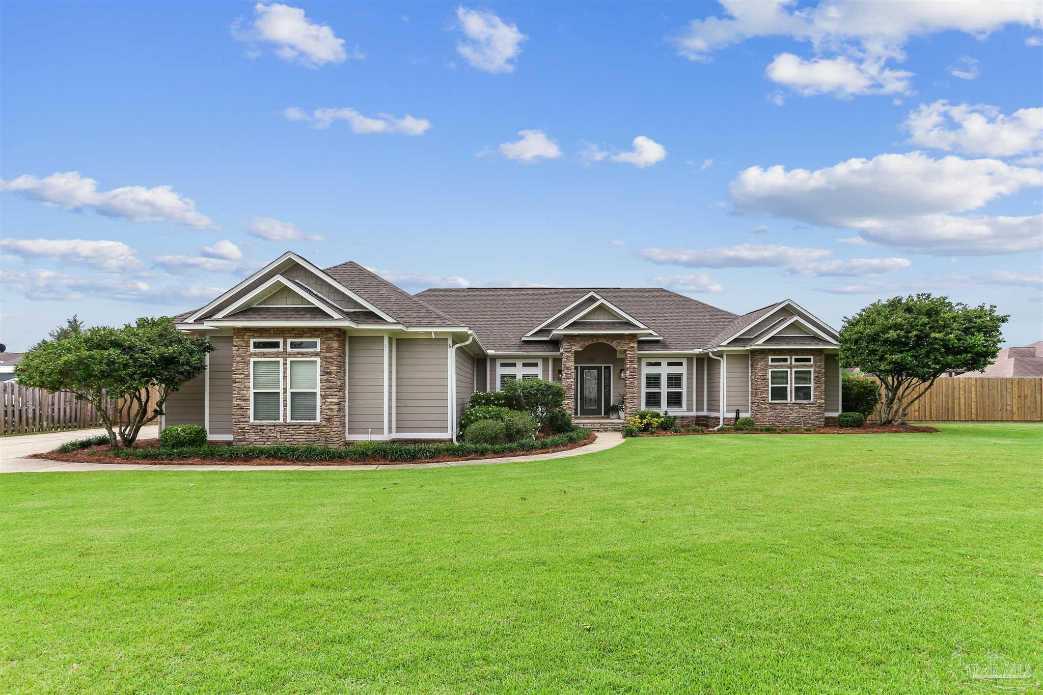 a front view of a house with a yard and green space