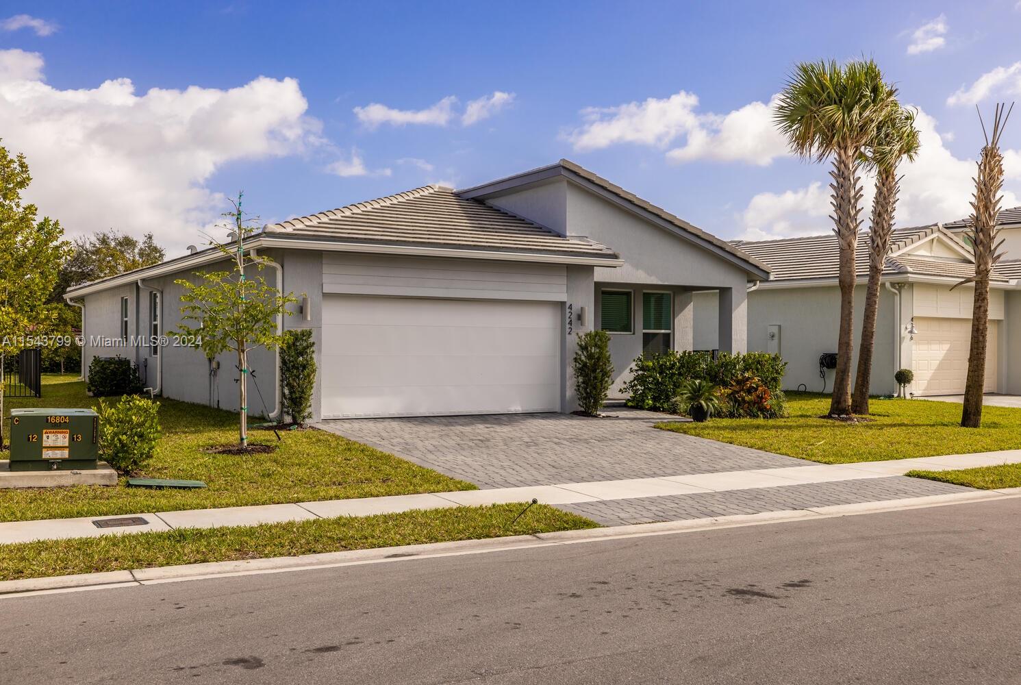 4242 Rosa Drive, Unit 4242 Deerfield Beach, FL 33064 - Photo 1 of 32 a house that has a tree in front of it