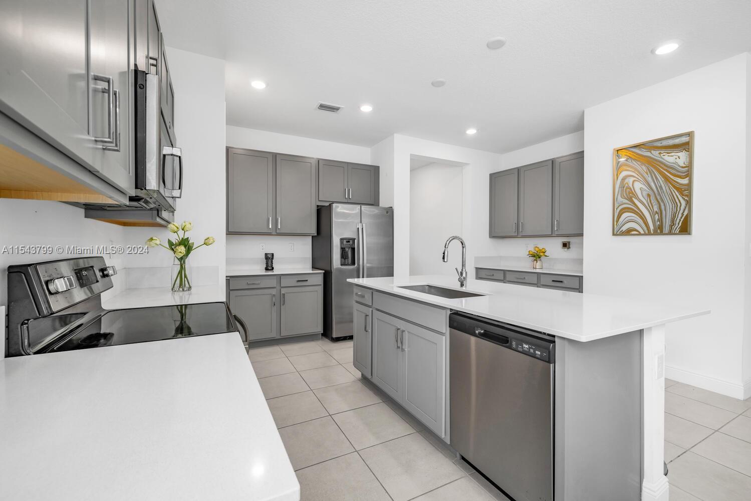 4242 Rosa Drive, Unit 4242 Deerfield Beach, FL 33064 - Photo 12 of 32 a kitchen with a sink stainless steel appliances and cabinets