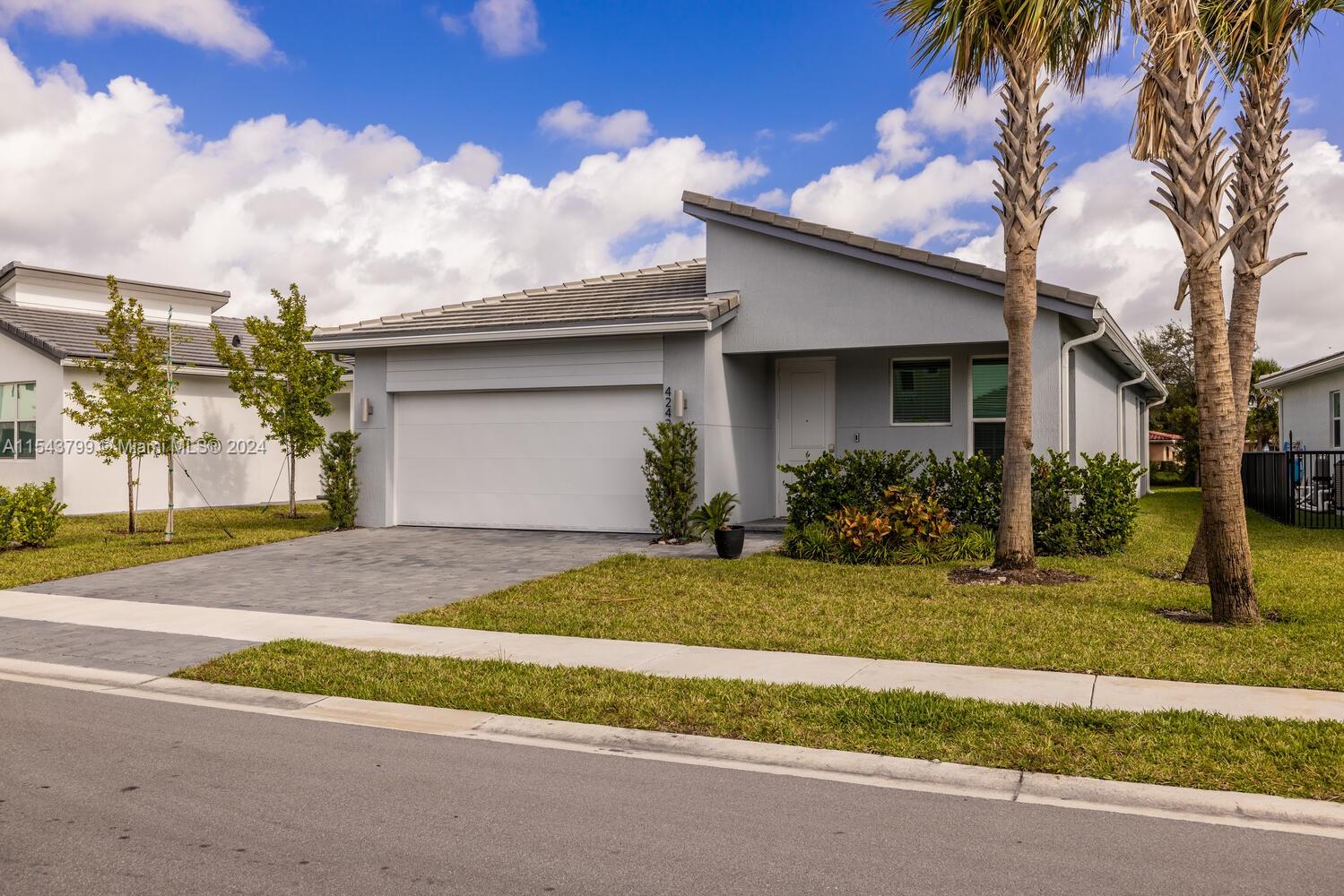 4242 Rosa Drive, Unit 4242 Deerfield Beach, FL 33064 - Photo 31 of 32 a white house that has a tree in front of it