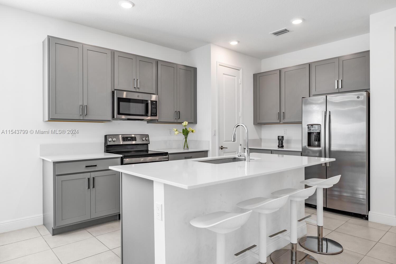 4242 Rosa Drive, Unit 4242 Deerfield Beach, FL 33064 - Photo 6 of 32 a kitchen with kitchen island a sink stove and refrigerator