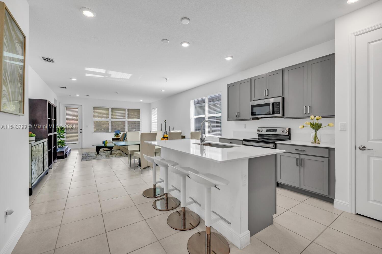 4242 Rosa Drive, Unit 4242 Deerfield Beach, FL 33064 - Photo 7 of 32 a kitchen with sink cabinets and appliances
