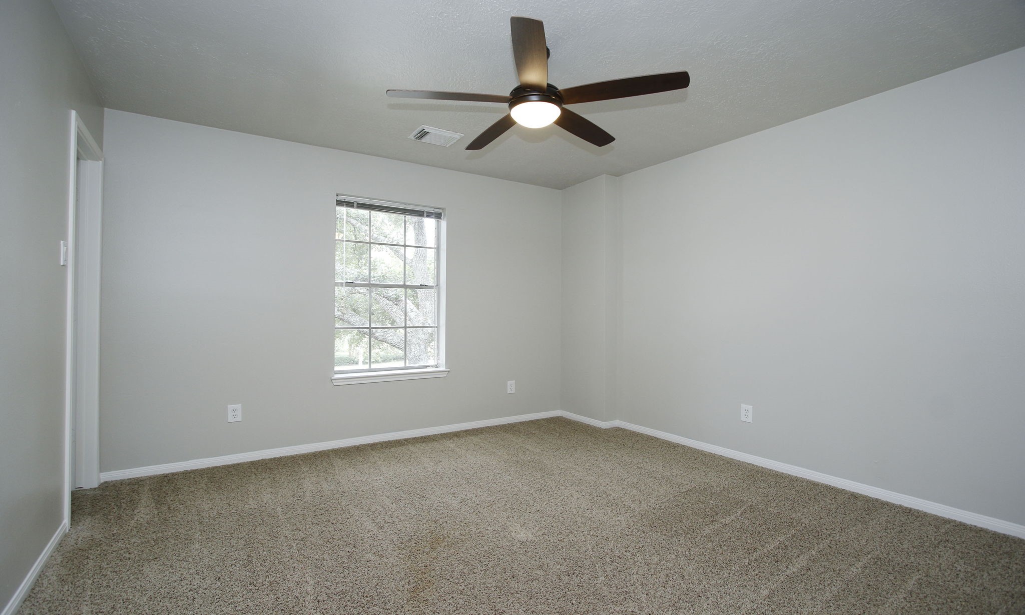 1915 West Welsford Drive Spring, TX 77386 - Photo 37 of 48 an empty room with a window and a fan